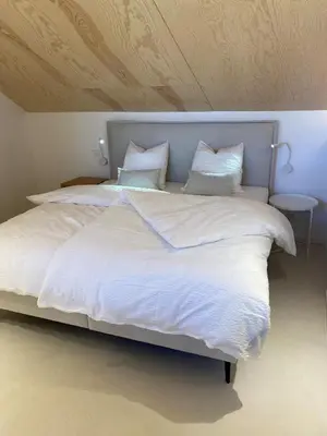 a large white bed with white sheets and pillows at Weserwasser in Eupen