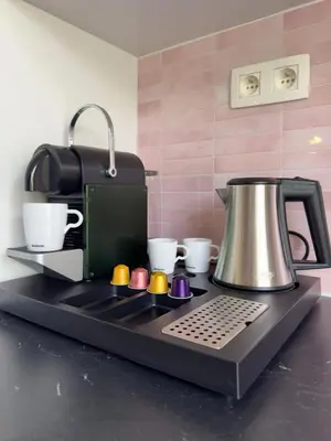 a kitchen counter with a coffee maker and coffee cups at Genk Central Apartment in Genk