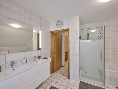 a bathroom with two sinks and a walk in shower at Hesbein in Tongeren