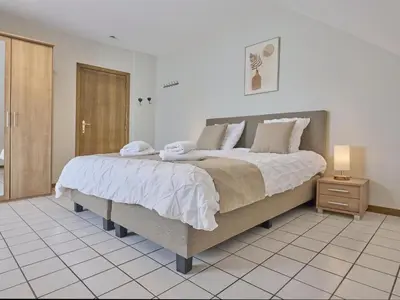 a bedroom with a large bed with towels on it at Hesbein in Tongeren
