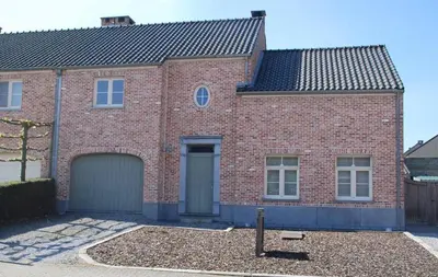 a red brick house with a garage at Vakantiewoning Huys op de Locht in Scherpenberg