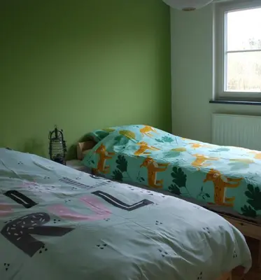 a bedroom with a bed with a comforter on it at Vakantiewoning Huys op de Locht in Scherpenberg