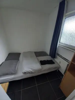 a bed in a small room with a window at Ap76 Nature Ardennes Economy class apartment in La Calamine