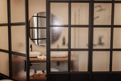 a bathroom with a glass door with a mirror at Guesthouse Just Be Mine in Beringen