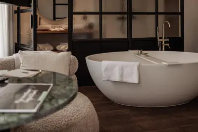 a bathroom with a white tub and a glass table at Guesthouse Just Be Mine in Beringen