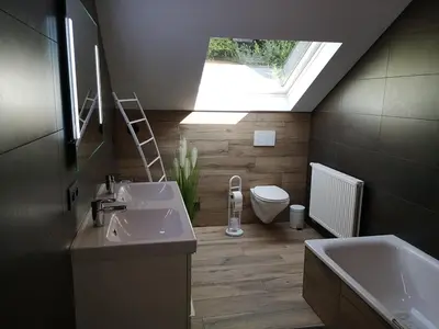 a bathroom with two sinks and a toilet and a skylight at Au Natur'elle in Gemmenich