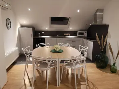 a kitchen with a table and chairs in a room at Au Natur'elle in Gemmenich