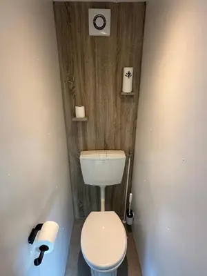 a bathroom with a toilet and two rolls of toilet paper at Chalet Tibi in Bocholt