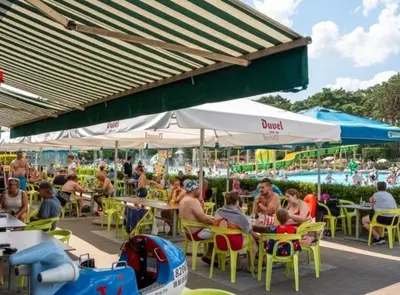 a group of people sitting at tables at an outdoor restaurant at Chalet Tibi in Bocholt