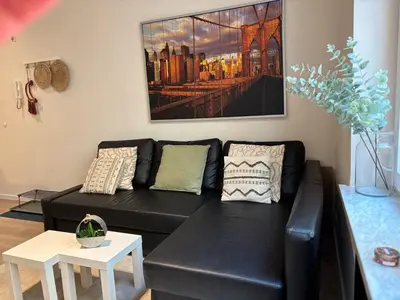 a black leather couch in a living room at Le coeur Liégeois - Hypercentre quartier piéton in Liège