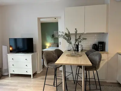a kitchen with a table and chairs and a bedroom at Le coeur Liégeois - Hypercentre quartier piéton in Liège