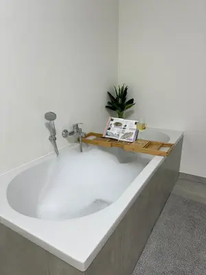 a large bath tub with a book on top of it at House with garden, fireplace and hot tub in Kinrooi
