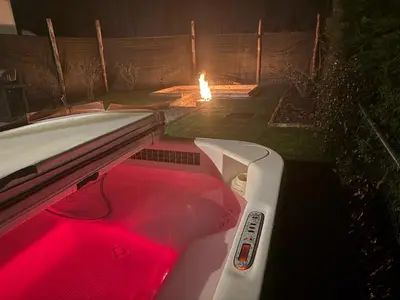 a bathtub with a red liquid in it with a fire in the background at House with garden, fireplace and hot tub in Kinrooi
