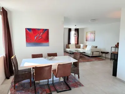 a living room with a white table and chairs at House with garden, fireplace and hot tub in Kinrooi