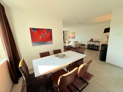 a dining room with a white table and chairs at House with garden, fireplace and hot tub in Kinrooi