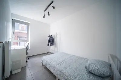 a white bedroom with a bed and a window at Liège 3 Bedroom Apartment, Quiet and Central in Liège