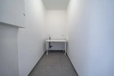 a white room with a table and a white wall at Liège 3 Bedroom Apartment, Quiet and Central in Liège