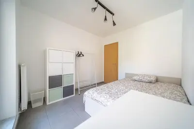 a white bedroom with a bed and a dresser at Liège 3 Bedroom Apartment, Quiet and Central in Liège