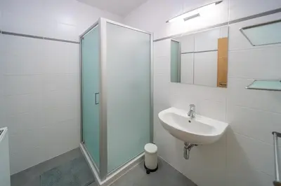 a white bathroom with a sink and a mirror at Liège 3 Bedroom Apartment, Quiet and Central in Liège