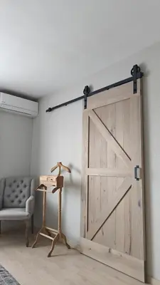 a sliding barn door in a room with a couch at holiday home Zonnestraal in Zonhoven