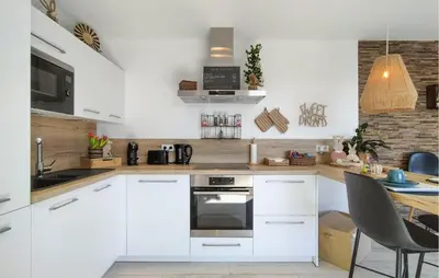 a kitchen with white cabinets and a table with a laptop at 1 Bedroom Lovely Apartment In Visé in Visé