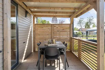 a screened porch with a table and chairs on it at Holiday home La Casetta in Kinrooi