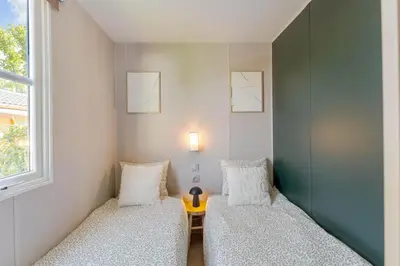 two beds in a room with a table and a window at Holiday home La Casetta in Kinrooi