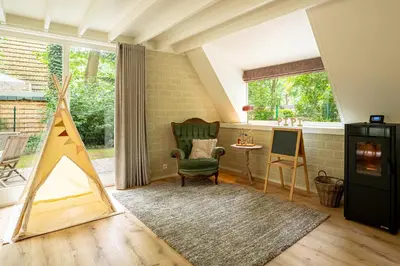 a living room with a tent and a chair at Boshuisje Rekem - Nilsson in Lanaken