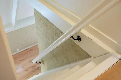 a staircase in a home with a white stair case at Boshuisje Rekem - Nilsson in Lanaken