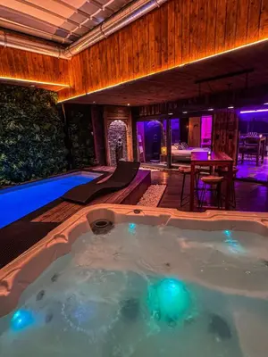a jacuzzi tub in a house with purple lights at Clos des Thermes-Secret Garden in Liège