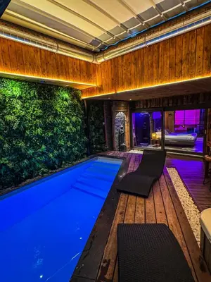 a swimming pool in a house with a green wall at Clos des Thermes-Secret Garden in Liège
