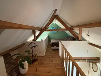 a attic room with wooden floors and wooden beams at Bakhuisje Peer in Peer