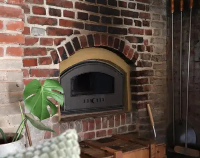 a brick fireplace with a tv in a brick wall at Bakhuisje Peer in Peer