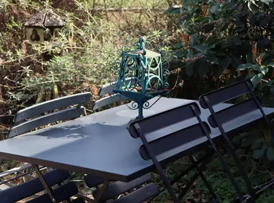 a picnic table with two chairs and a lantern on it at Bakhuisje Peer in Peer