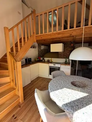 a kitchen and dining room with a table and stairs at Bakhuisje Peer in Peer