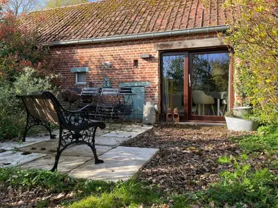 a bench sitting in front of a brick house at Bakhuisje Peer in Peer