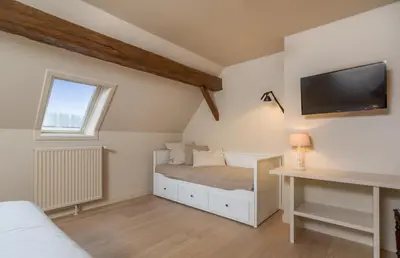 a bedroom with a bed and a tv on the wall at Domein Marsnil in Heers