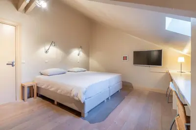 a bedroom with a bed and a flat screen tv at Domein Marsnil in Heers