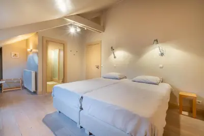 a bedroom with a large white bed in a room at Domein Marsnil in Heers