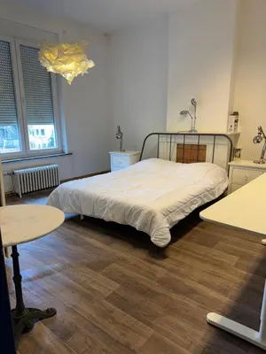 a bedroom with a bed and two tables at Le 21 - Appart 3 chambres - centre de Liège in Liège