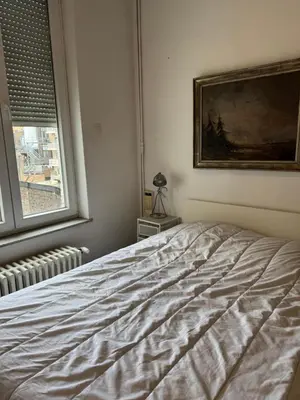 a bedroom with a bed and a painting on the wall at Le 21 - Appart 3 chambres - centre de Liège in Liège
