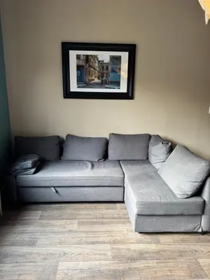 a couch in a living room with a picture on the wall at Le 21 - Appart 3 chambres - centre de Liège in Liège