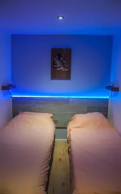 two beds in a room with a blue wall at Chalet Klein Geluk in Lanaken