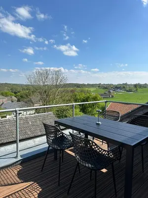 a table and chairs on the deck of a house at Residence Saint Lambert in Plombières