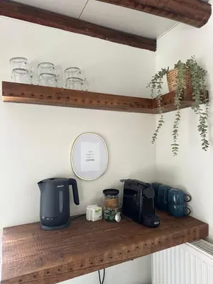 a shelf with a coffee maker and glasses on it at Residence Saint Lambert in Plombières