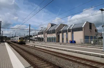a train on the tracks at a train station at L'appart en gare in Welkenraedt