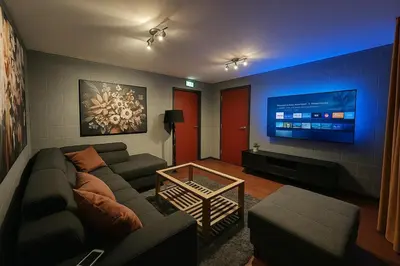a living room with a couch and a flat screen tv at L'appart en gare in Welkenraedt