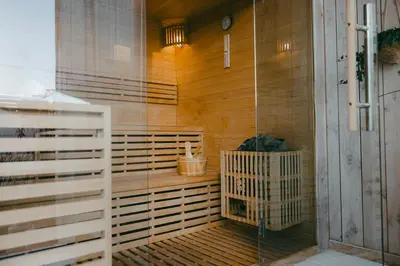 a sauna with a glass door in a room at Essential by cin in Zonhoven