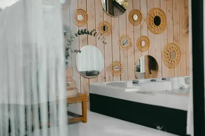 a bathroom with a sink and mirrors on a wooden wall at Essential by cin in Zonhoven