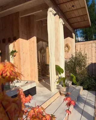 a porch of a house with wooden walls and a patio at Essential by cin in Zonhoven
